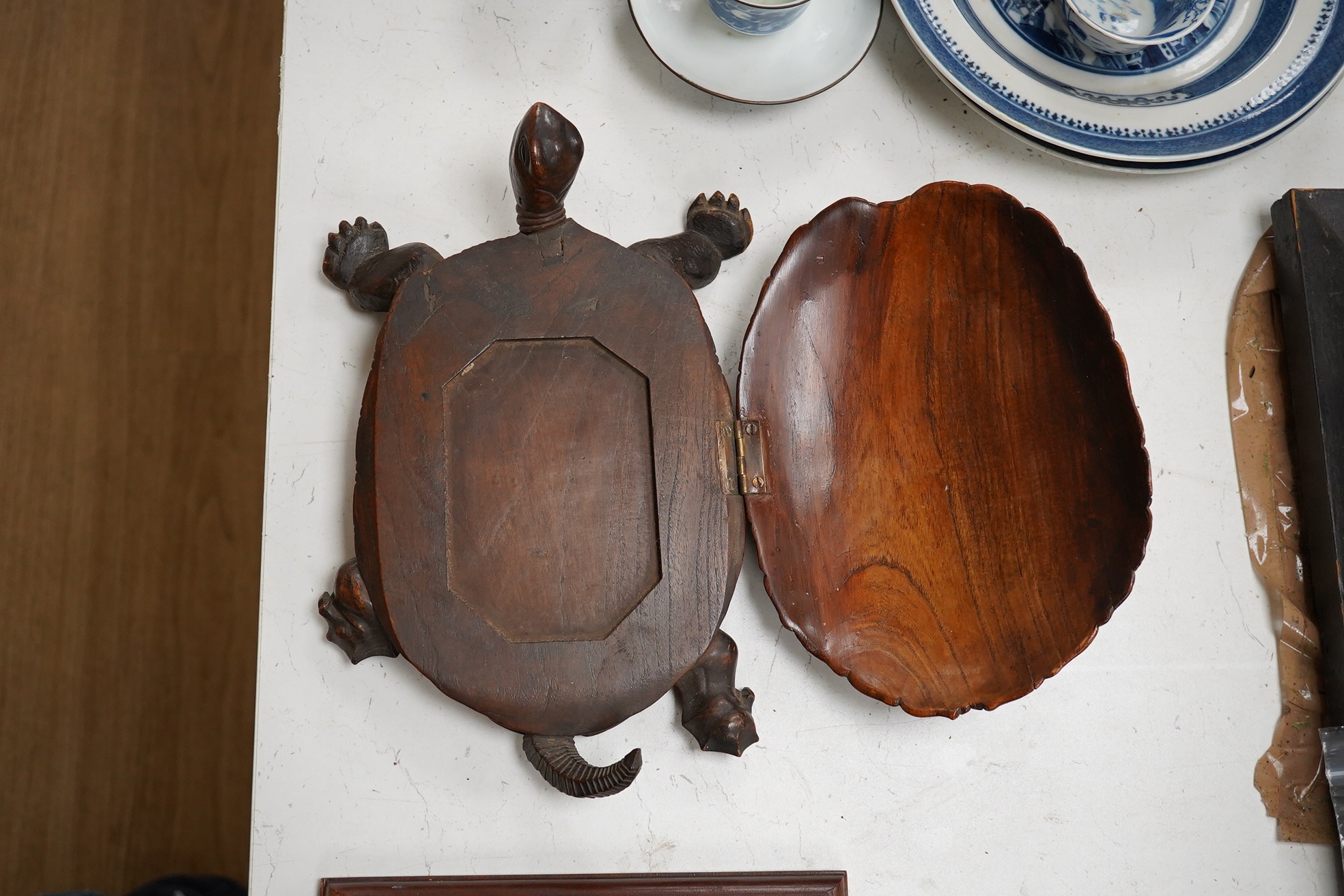 A late 19th century/early 20th century carved walnut box in the form of a tortoise, the shell opening to reveal a compartment, 29cm wide. Condition - fair, tail re-glued